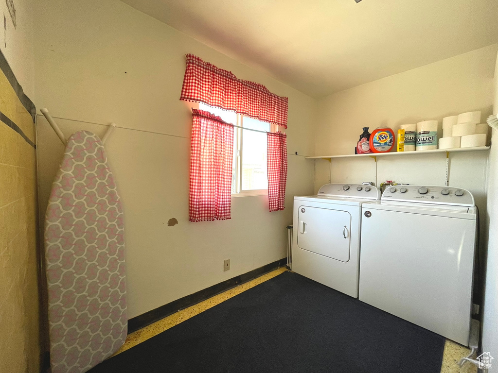 Clothes washing area featuring washer and clothes dryer and baseboards