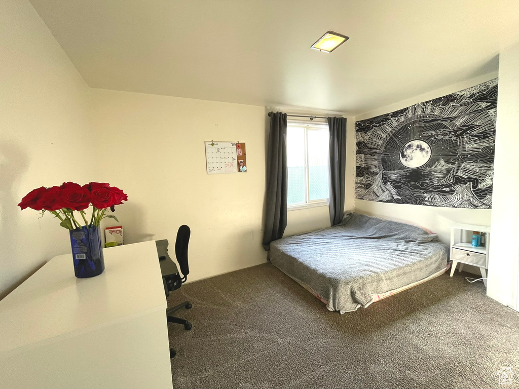 Bedroom with carpet flooring and a desk