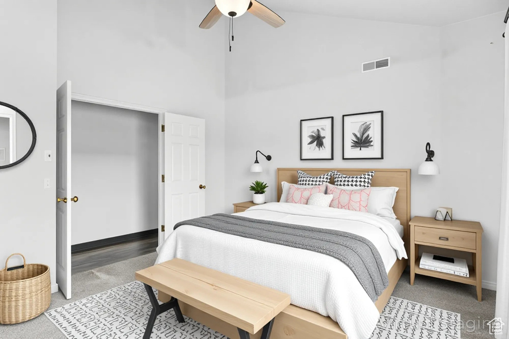 Bedroom featuring light colored carpet, high vaulted ceiling, baseboards, and ceiling fan
