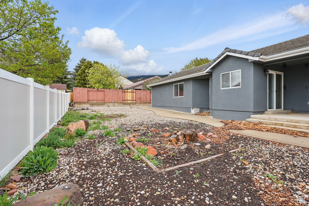 View of side of home with a fenced backyard and stucco siding