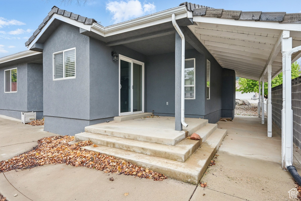 Rear view of property with stucco siding and fence
