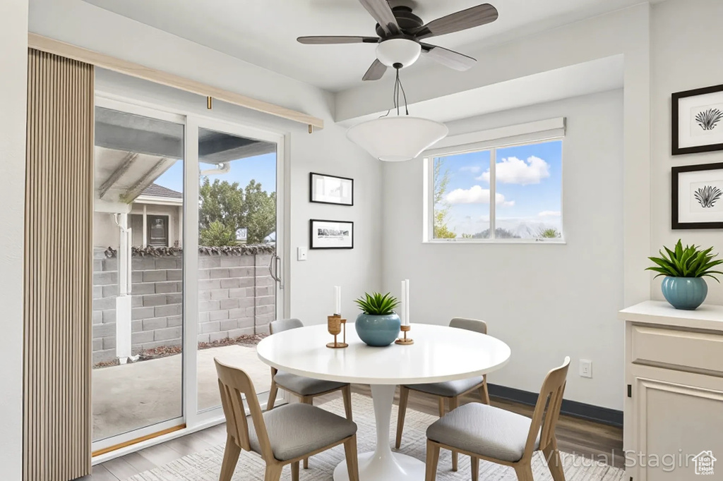 Dining space with wood finished floors, healthy amount of natural light, and a ceiling fan