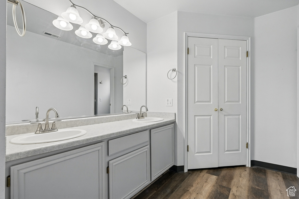 Full bathroom with double vanity and wood finished floors