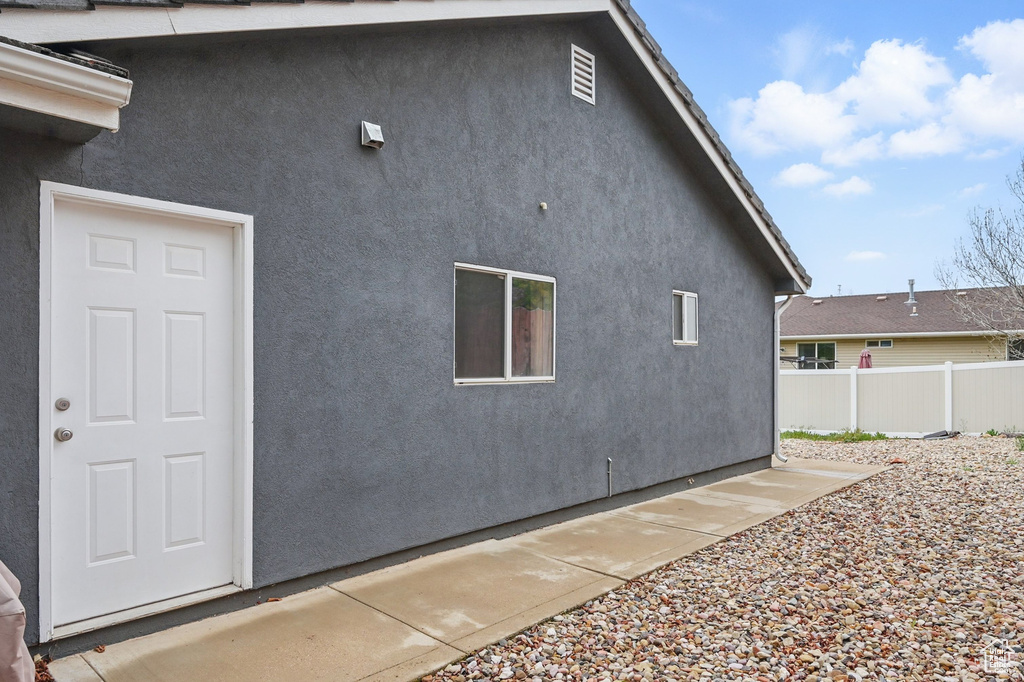 View of side of property with fence and stucco siding