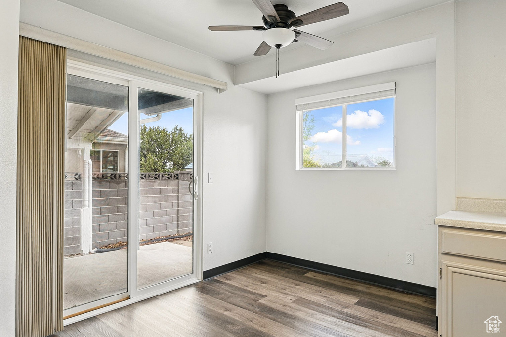 Doorway with wood finished floors, ceiling fan, and baseboards