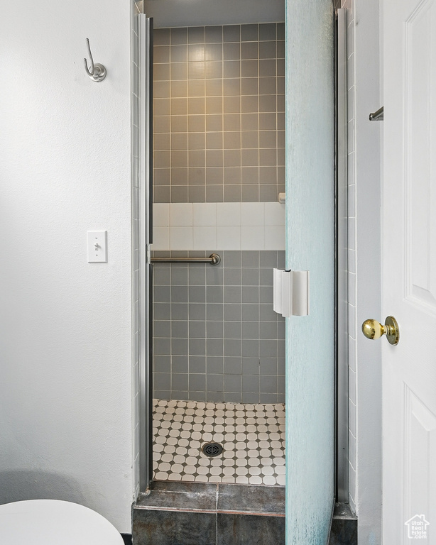 Full bath featuring a shower stall and toilet