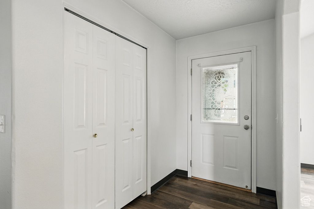 Doorway to outside with dark wood-style flooring