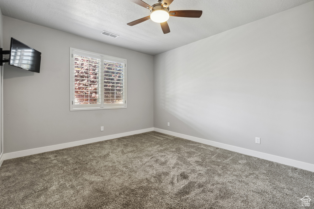 Empty room with ceiling fan, carpet, and baseboards