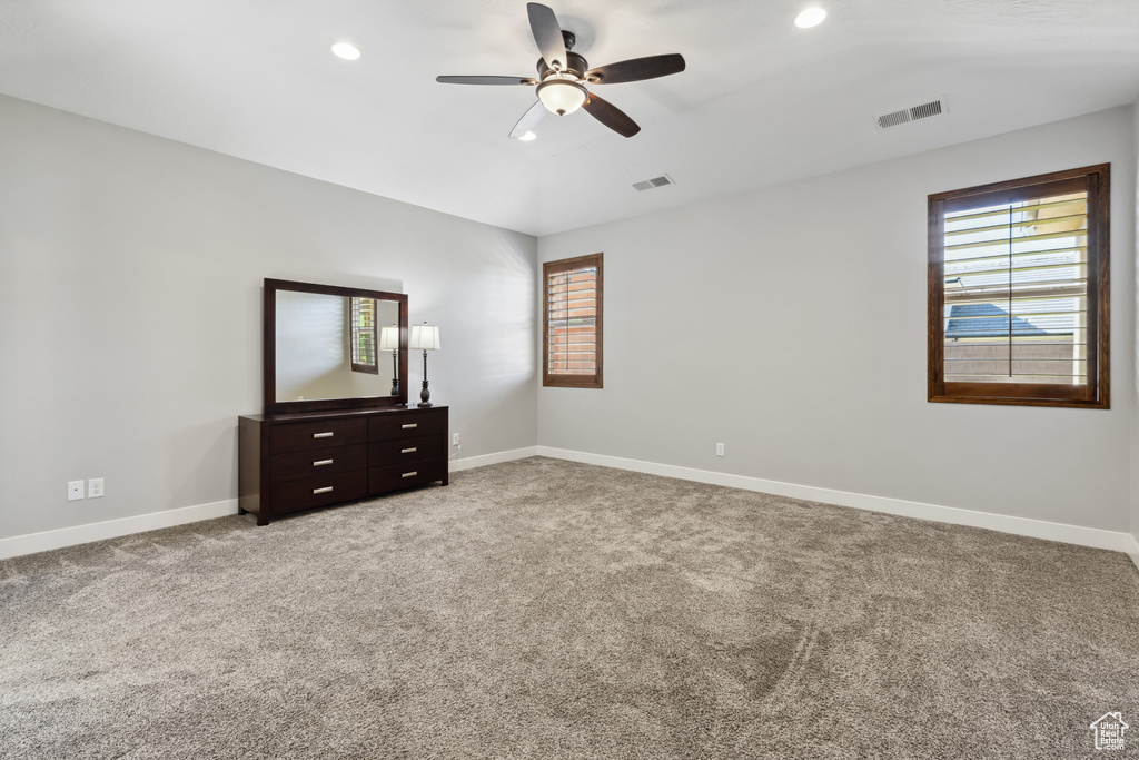 Unfurnished bedroom with multiple windows, recessed lighting, light carpet, and baseboards