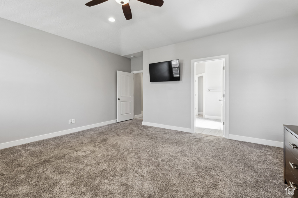 Unfurnished bedroom with carpet flooring, baseboards, and ceiling fan