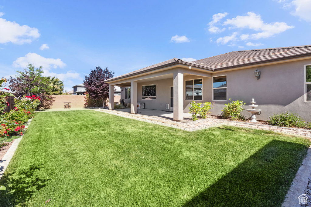 Back of house with a patio area, stucco siding, and a tile roof