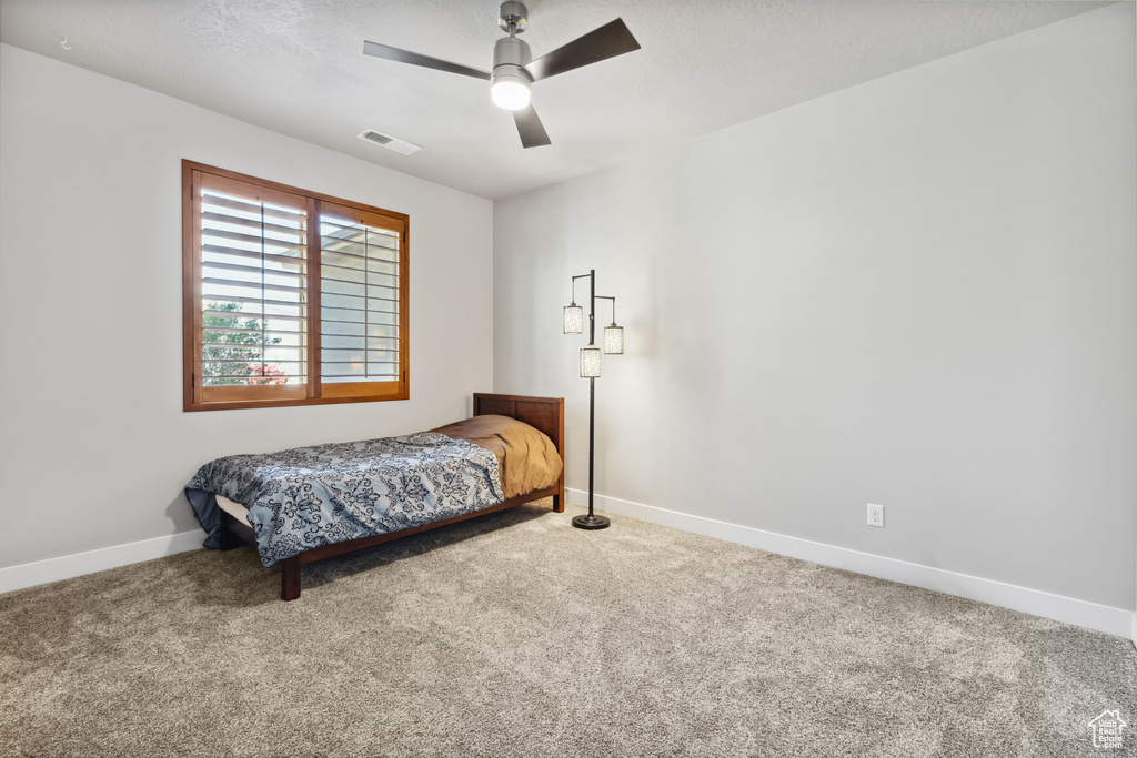 Bedroom featuring carpet, baseboards, and ceiling fan