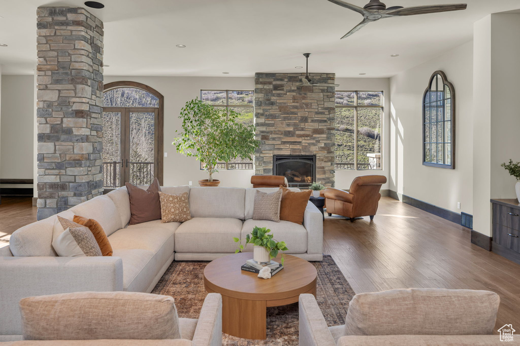 Living area with a ceiling fan, plenty of natural light, wood finished floors, baseboards, and recessed lighting