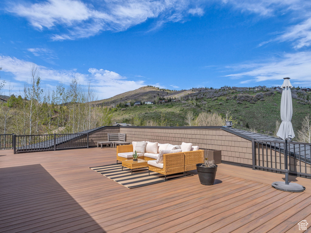 Wooden deck featuring an outdoor hangout area and a mountain view