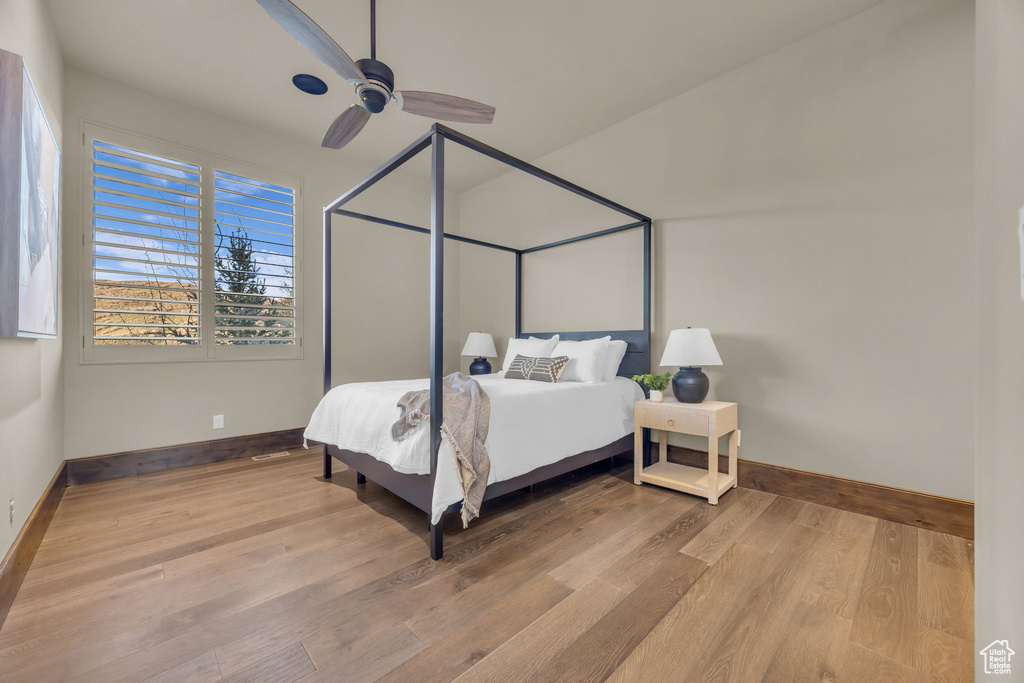 Bedroom with baseboards, wood finished floors, and ceiling fan