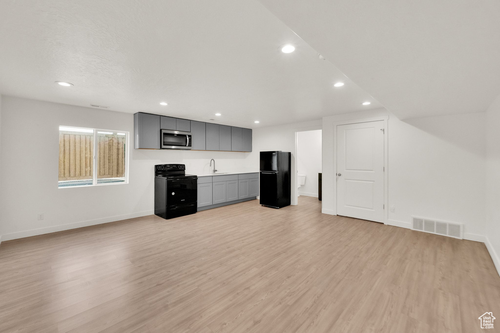 Kitchen with black appliances, gray cabinetry, baseboards, light wood-type flooring, and recessed lighting