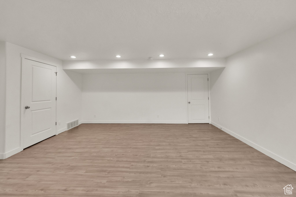 Basement featuring recessed lighting, light wood finished floors, and baseboards