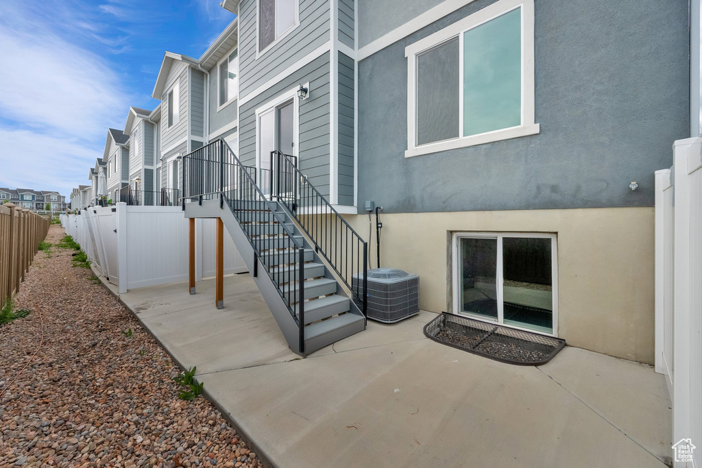 Property entrance with fence, a patio area, and stucco siding