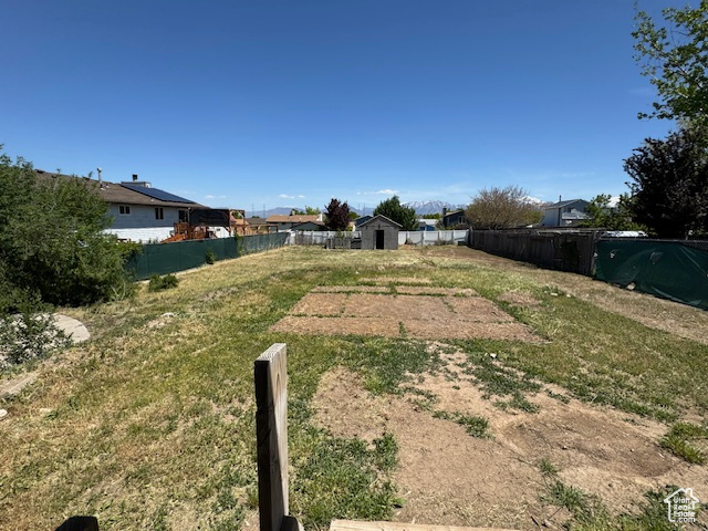 View of yard with fence and a storage unit