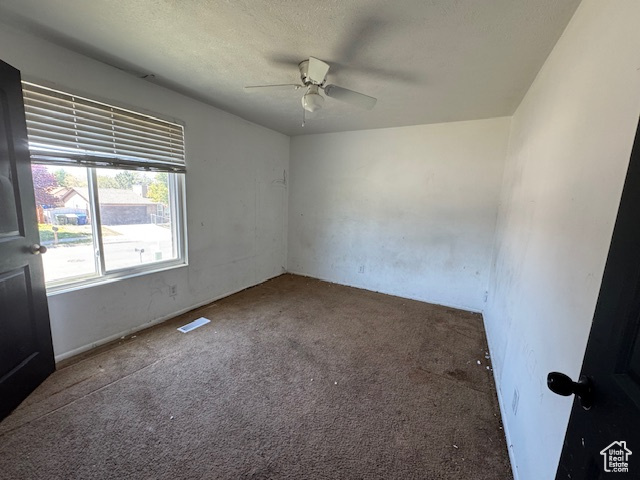 Spare room featuring a ceiling fan, carpet flooring, and a textured ceiling