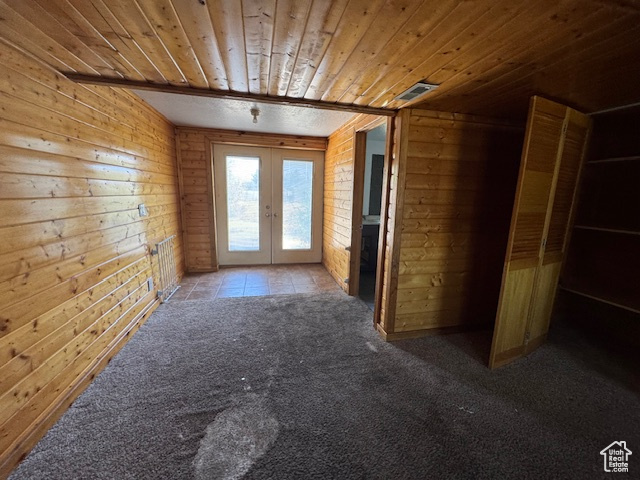 Bonus room featuring french doors, wood ceiling, carpet floors, wood walls, and tile patterned floors