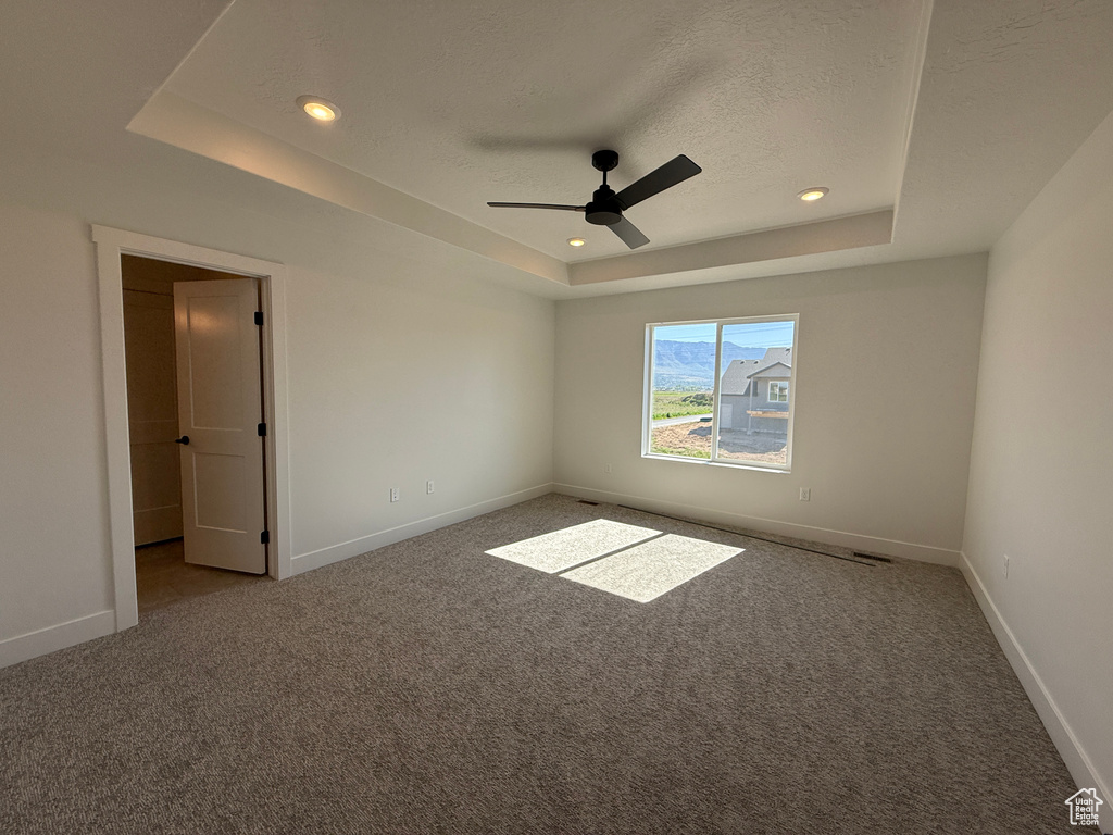 Unfurnished bedroom with a raised ceiling, carpet floors, baseboards, a textured ceiling, and recessed lighting