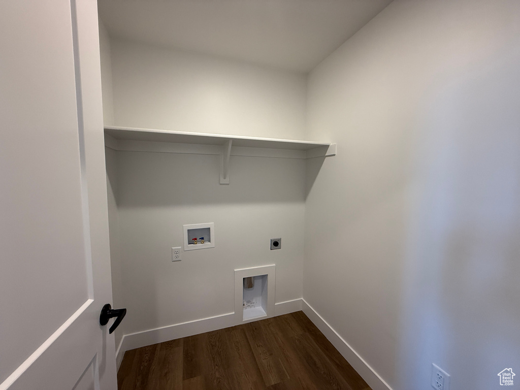 Clothes washing area with hookup for a washing machine, electric dryer hookup, dark wood finished floors, and baseboards