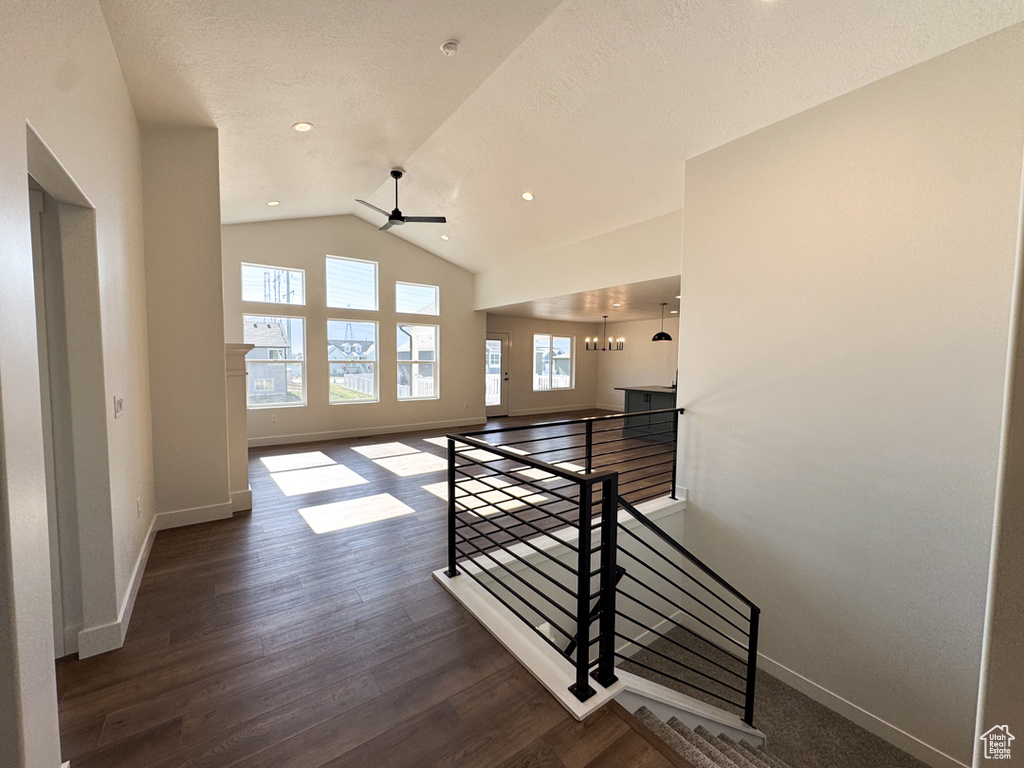 Hallway featuring an upstairs landing, vaulted ceiling, wood finished floors, and recessed lighting