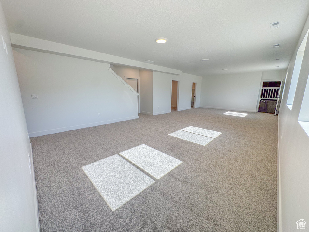 Carpeted spare room featuring baseboards