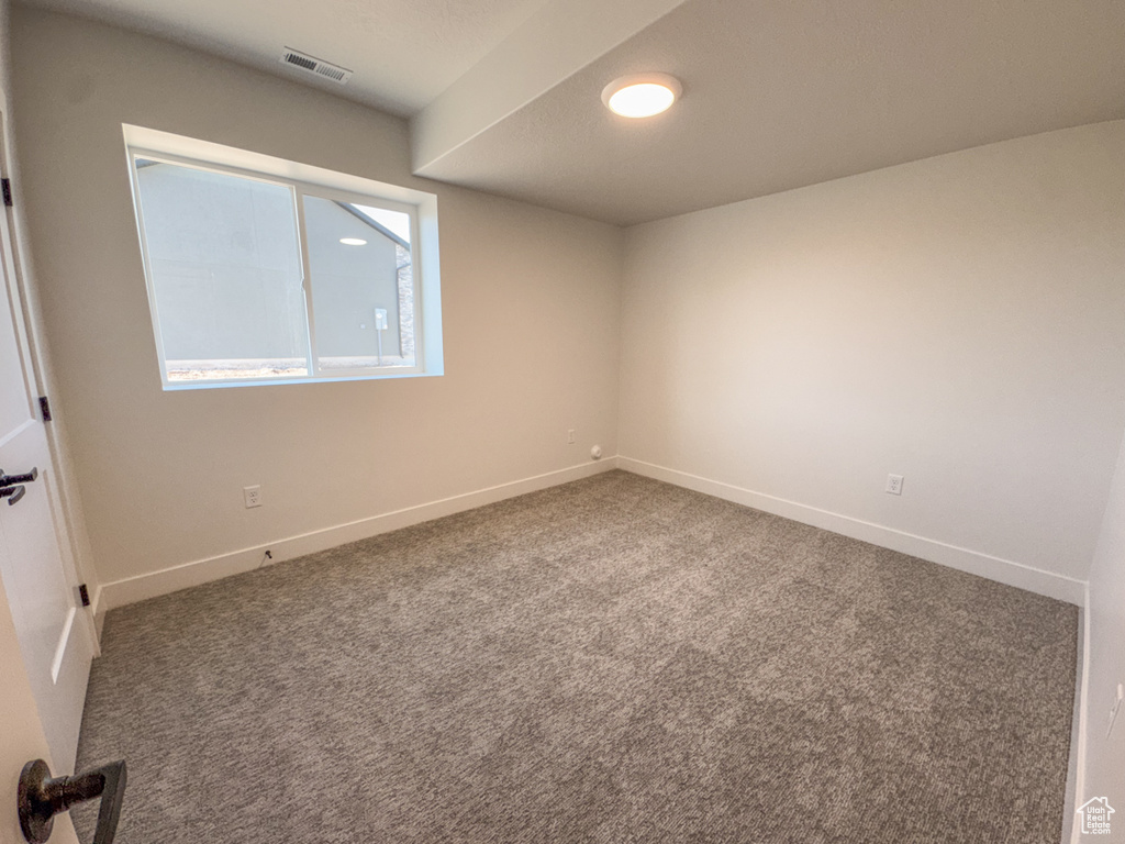 Spare room featuring baseboards and carpet floors