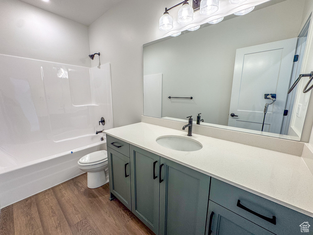 Full bathroom featuring wood finished floors, vanity, and tub / shower combination