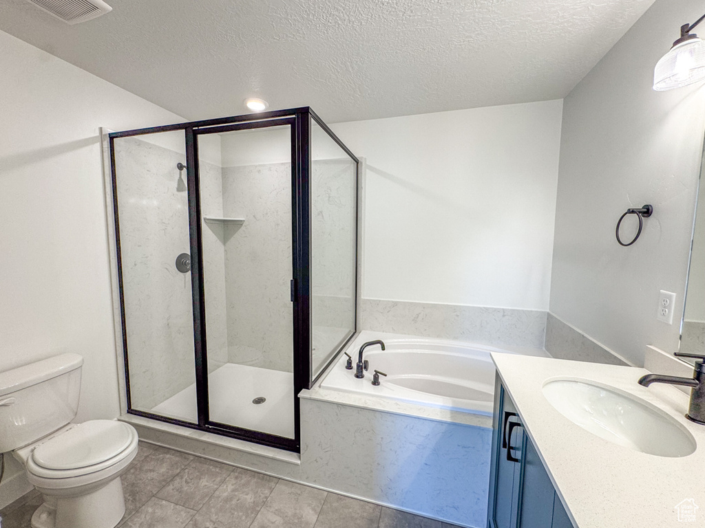 Full bath with a textured ceiling, a bath, vanity, and a shower stall