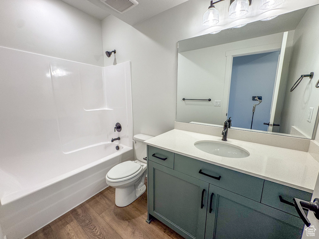 Full bath featuring wood finished floors,  shower combination, and vanity