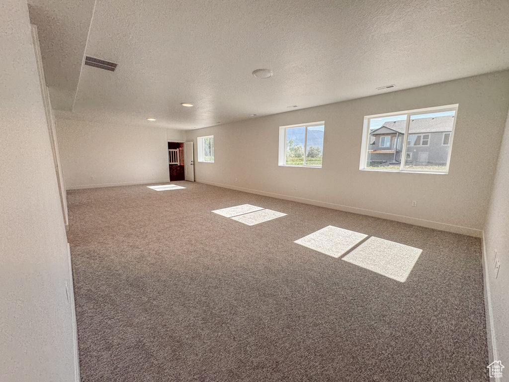 Spare room featuring a textured ceiling, carpet flooring, and recessed lighting