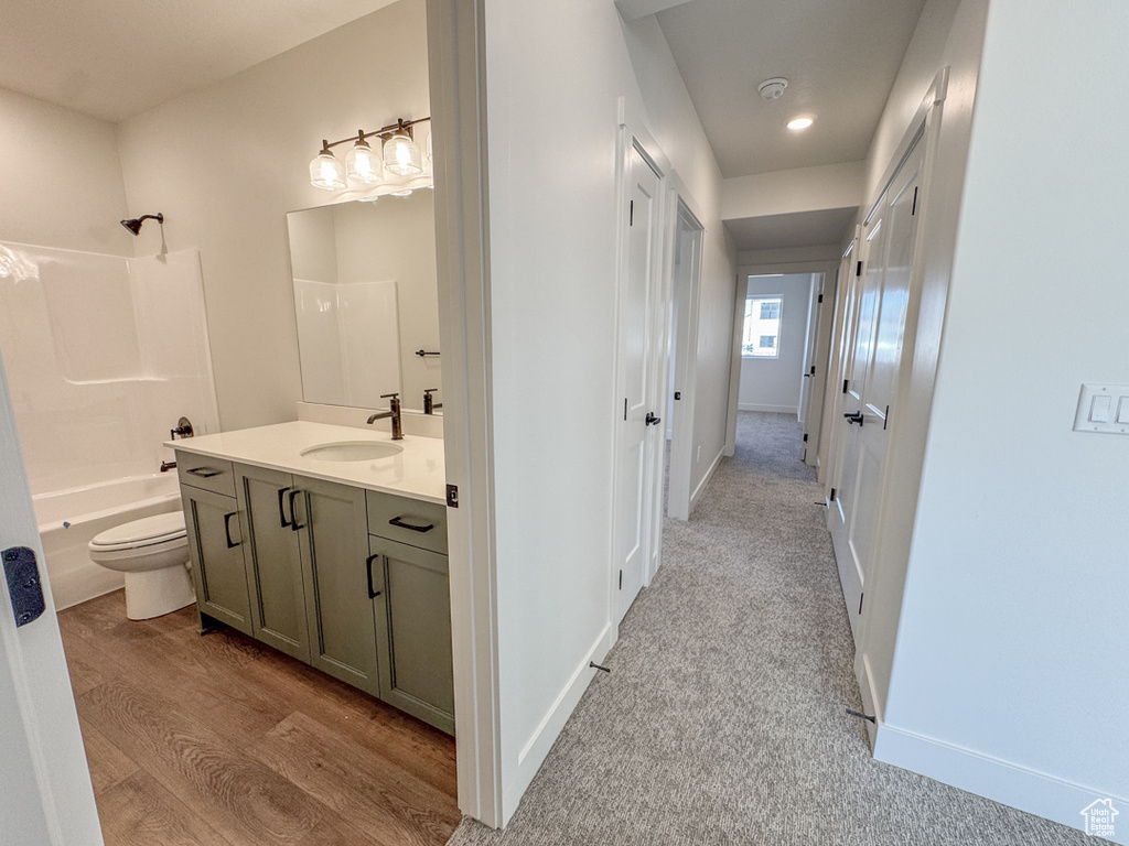Bathroom with vanity, bathing tub / shower combination, wood finished floors, and recessed lighting