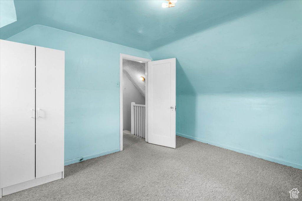 Bonus room featuring vaulted ceiling and carpet floors