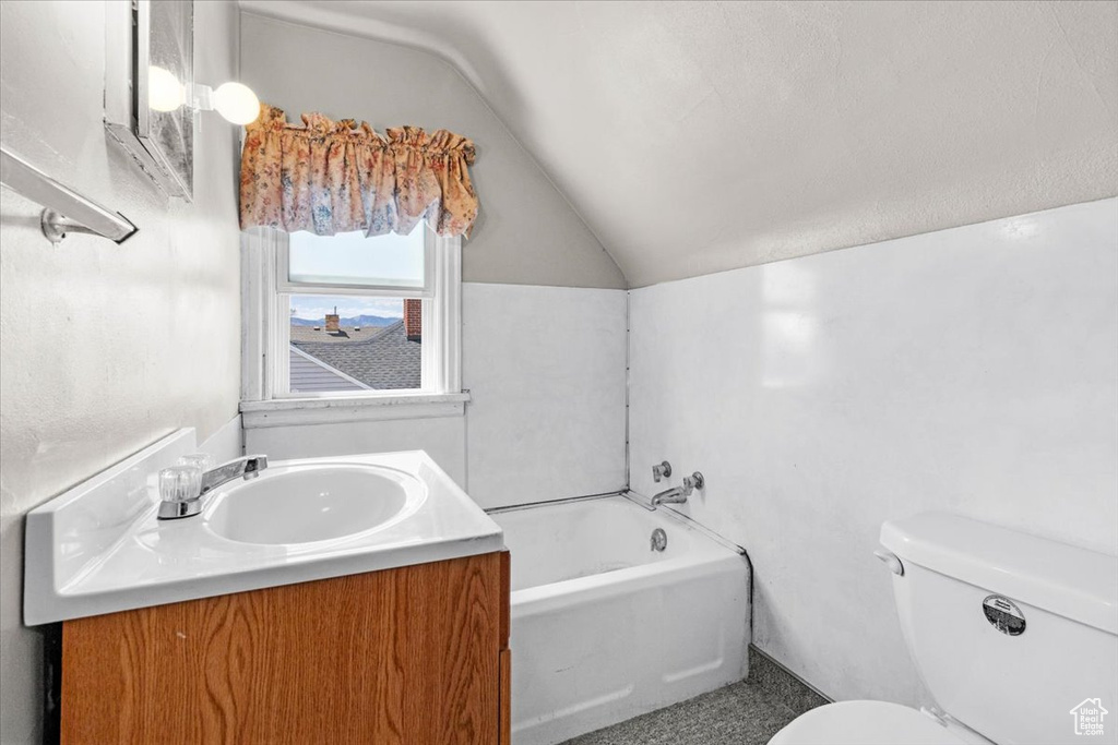Full bathroom featuring lofted ceiling, toilet, a garden tub, and vanity