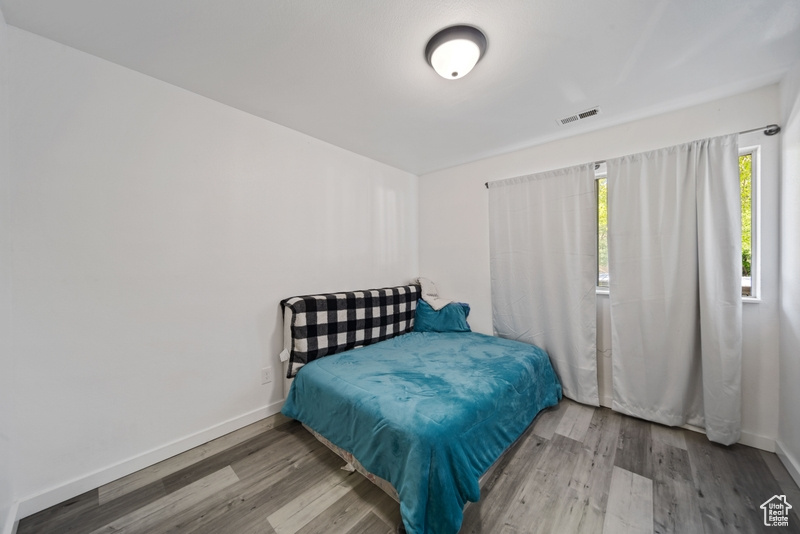 Bedroom with wood finished floors and baseboards