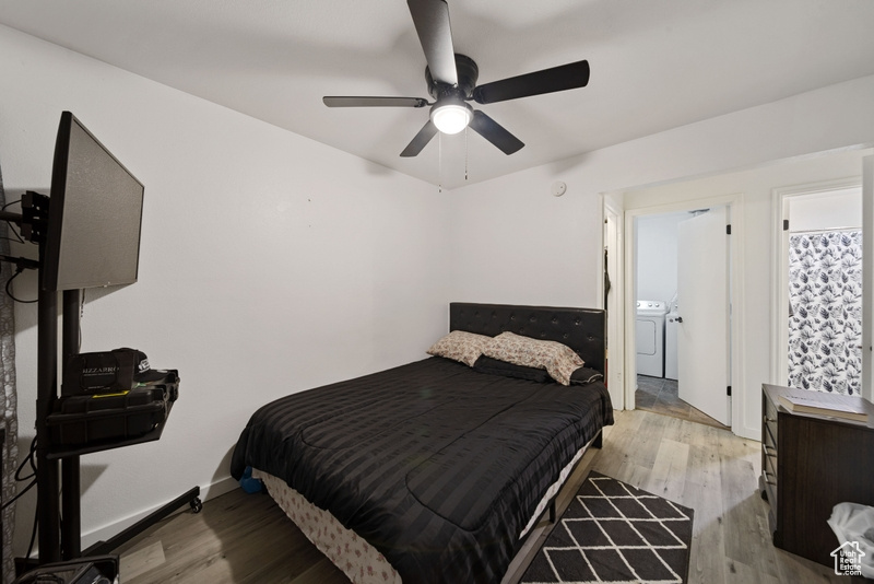Bedroom featuring washer and clothes dryer, wood finished floors, and a ceiling fan