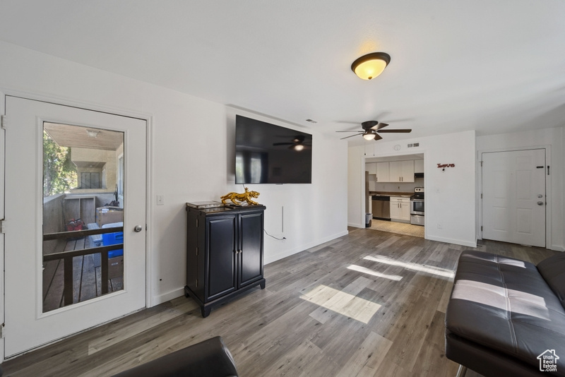 Living room featuring a ceiling fan, wood finished floors, and baseboards