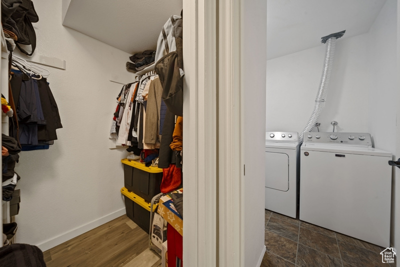 Clothes washing area featuring washing machine and dryer and baseboards