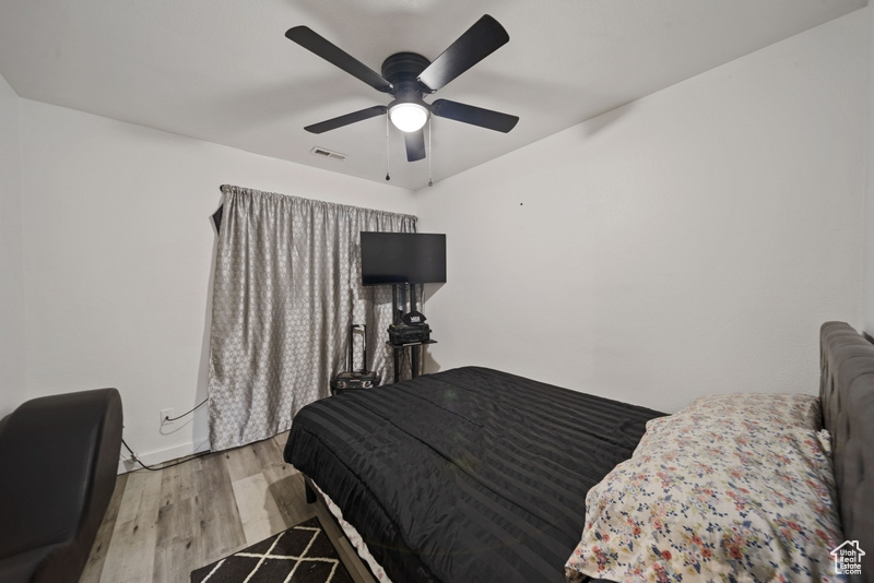 Bedroom with light wood finished floors and a ceiling fan