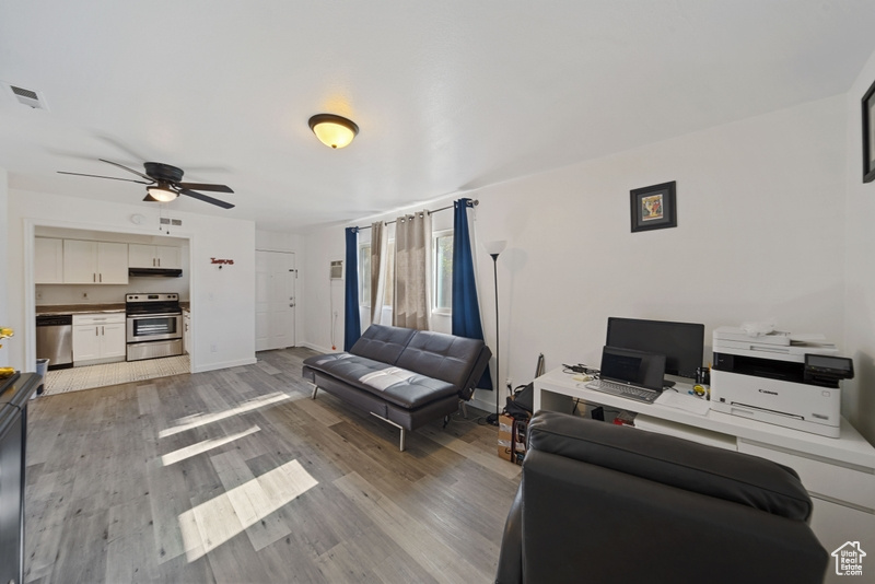 Living area with ceiling fan, light wood-style flooring, baseboards, and an office area