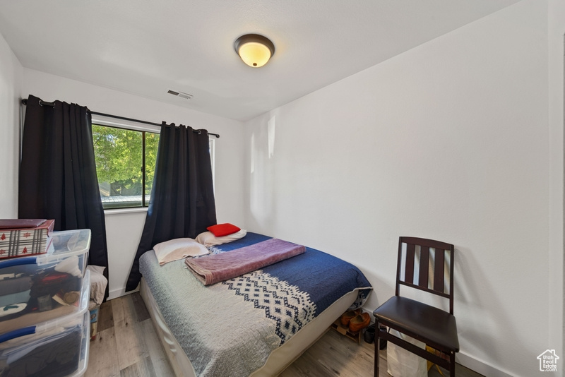 Bedroom with wood finished floors and baseboards