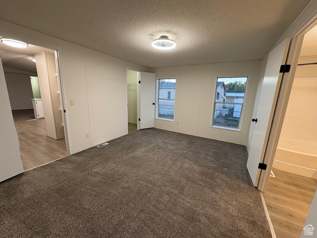 Spare room featuring light wood finished floors and a textured ceiling