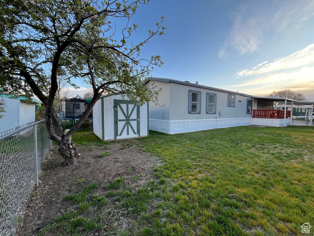 Back of property featuring a storage shed and an outbuilding
