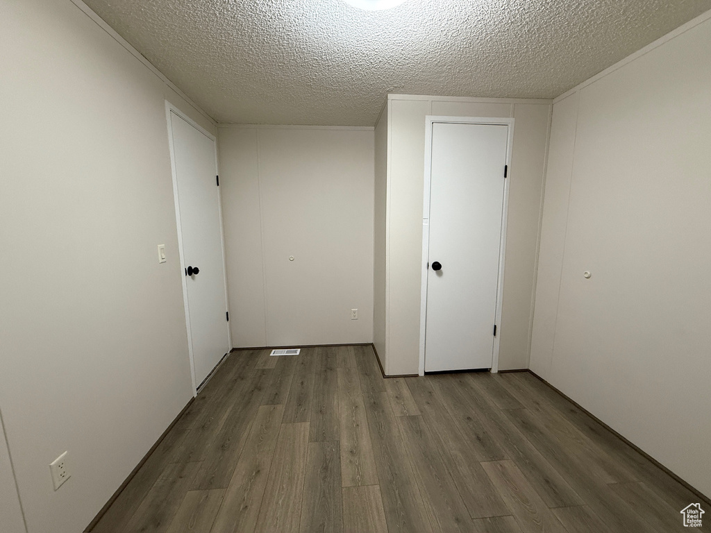 Spare room featuring wood finished floors and a textured ceiling