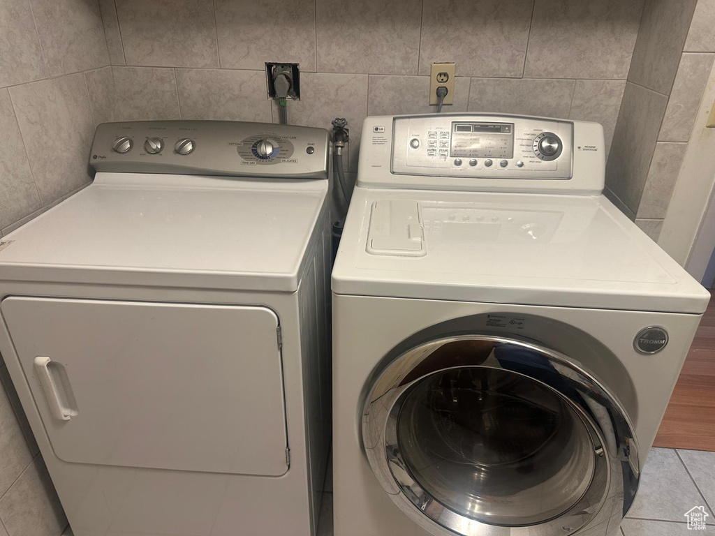 Washroom featuring washing machine and clothes dryer and tile patterned floors