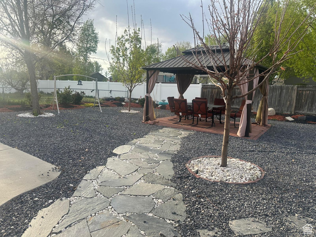 Fenced backyard featuring a gazebo and a patio