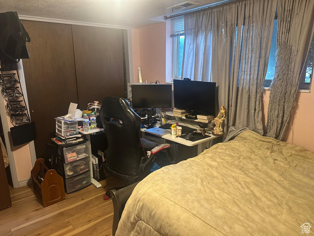 Bedroom featuring wood finished floors and a desk